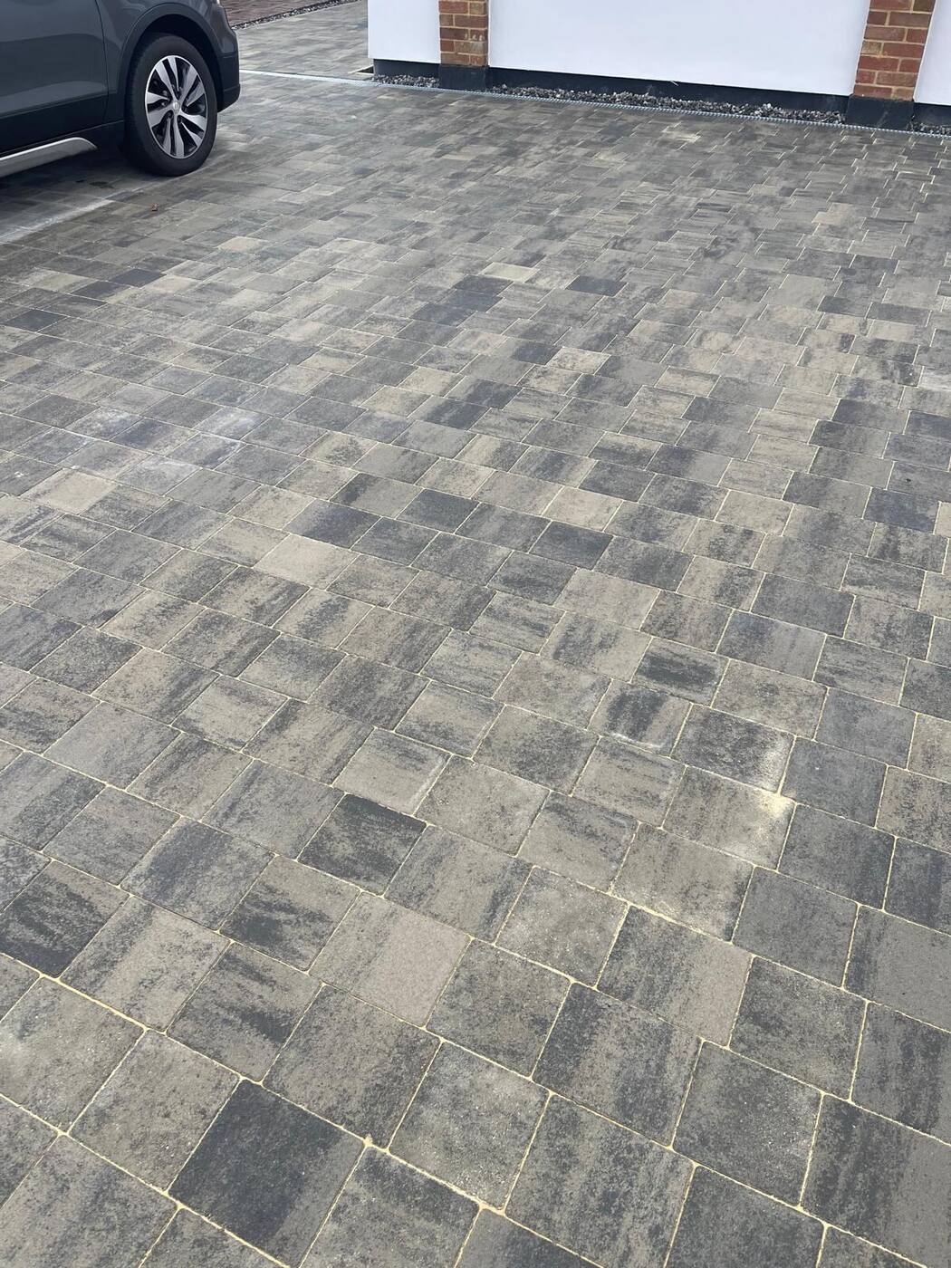 Block paving driveway close up beside parked car