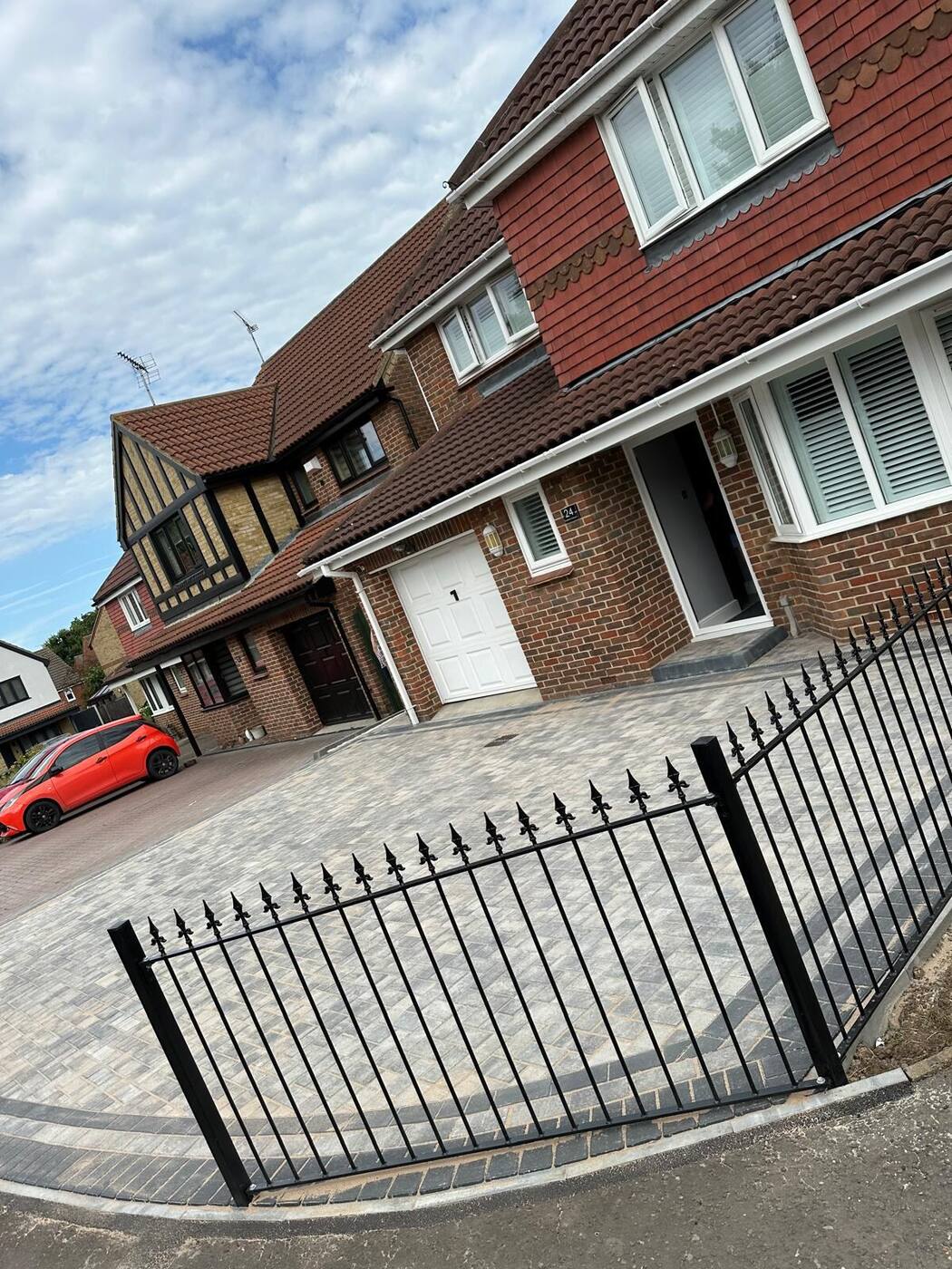 Wrought iron railings along a new block paved driveway
