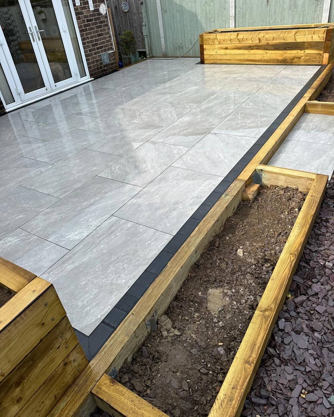 Porcelain patio with timber raised beds under construction