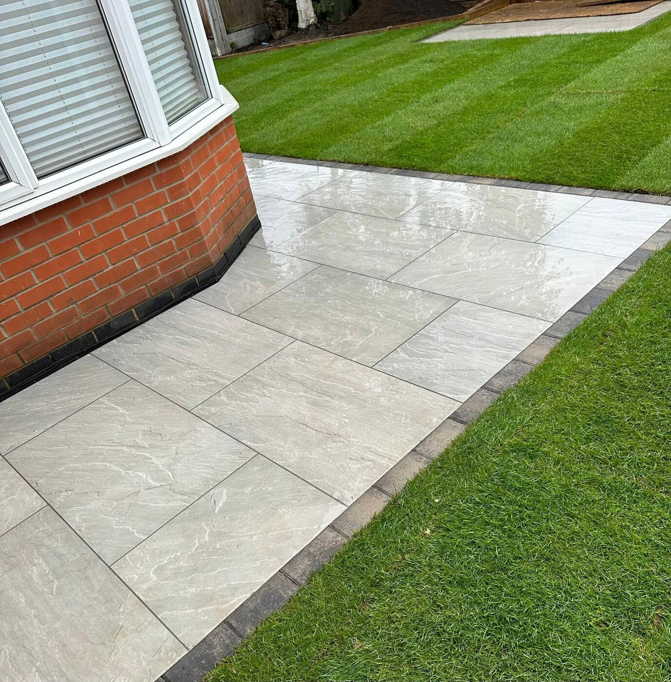 Grey porcelain patio with sleeper-edged lawn, Essex garden